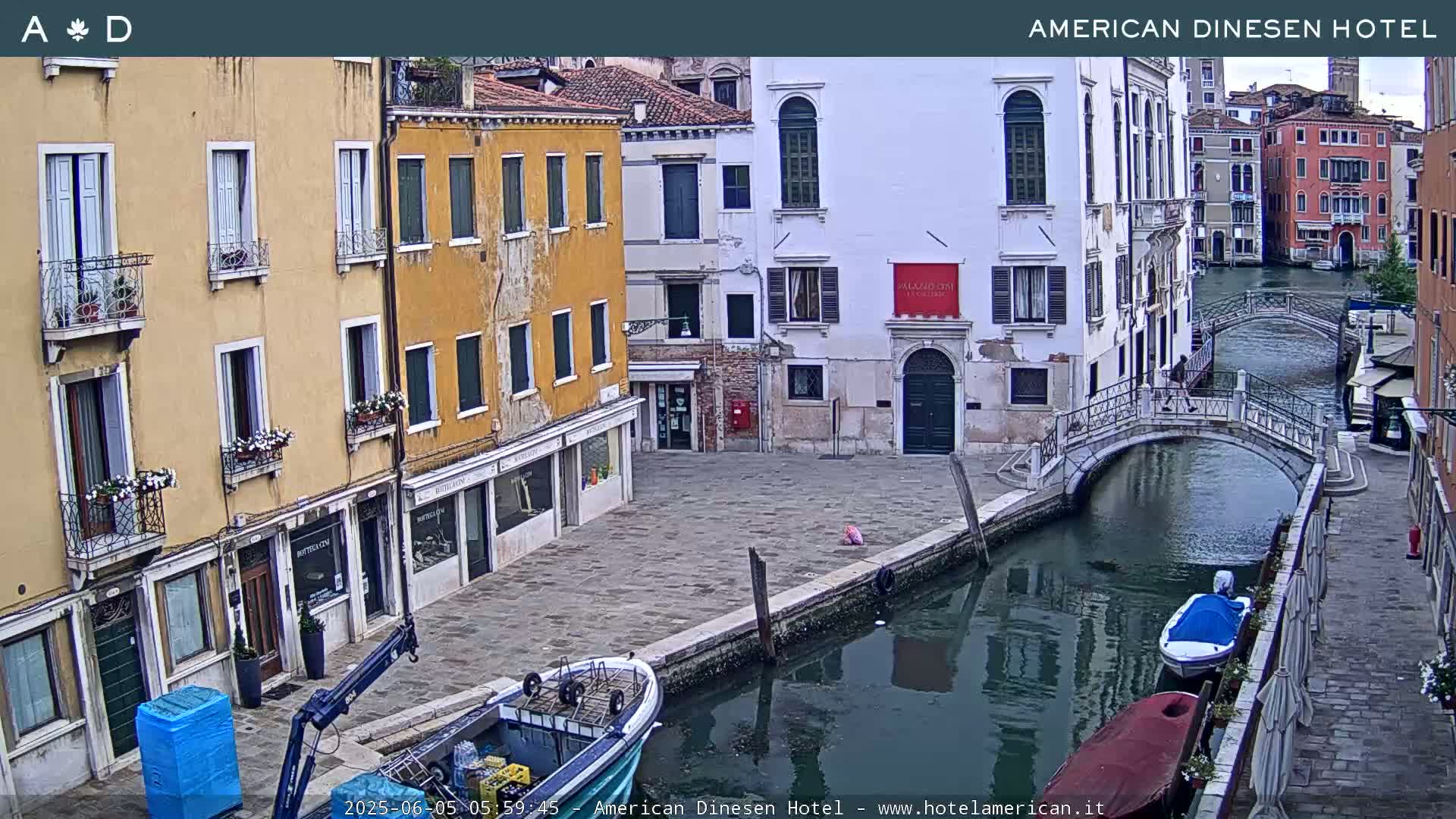 A canal in Venice, Italy, with several buildings lining its banks, is shown on an overcast day; boats are moored along the canal.