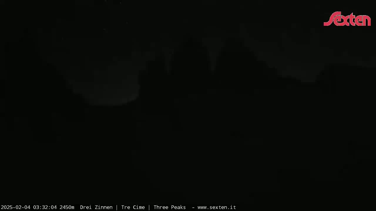 A very dark image shows an indistinct, possibly mountainous landscape under a night sky.