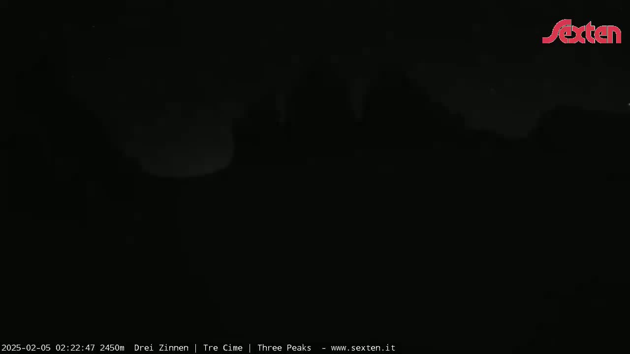 A dark, nighttime image shows a dimly lit landscape under a mostly clear sky.