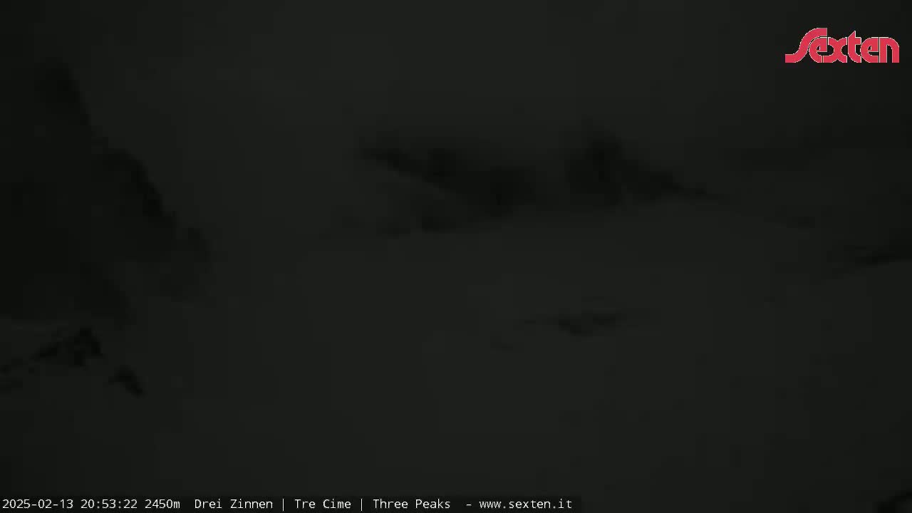 A dark, nighttime, snowy landscape is visible under cloudy conditions.