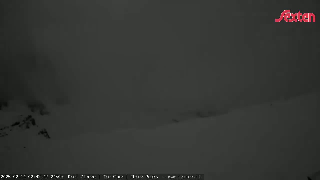 A snowy, overcast landscape is visible, with a low-lying cloud cover obscuring the view.