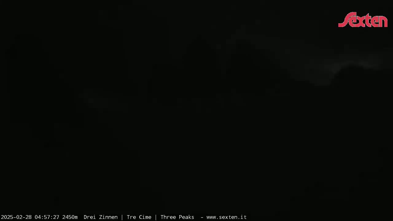 A dark, nighttime outdoor scene with faint clouds visible.