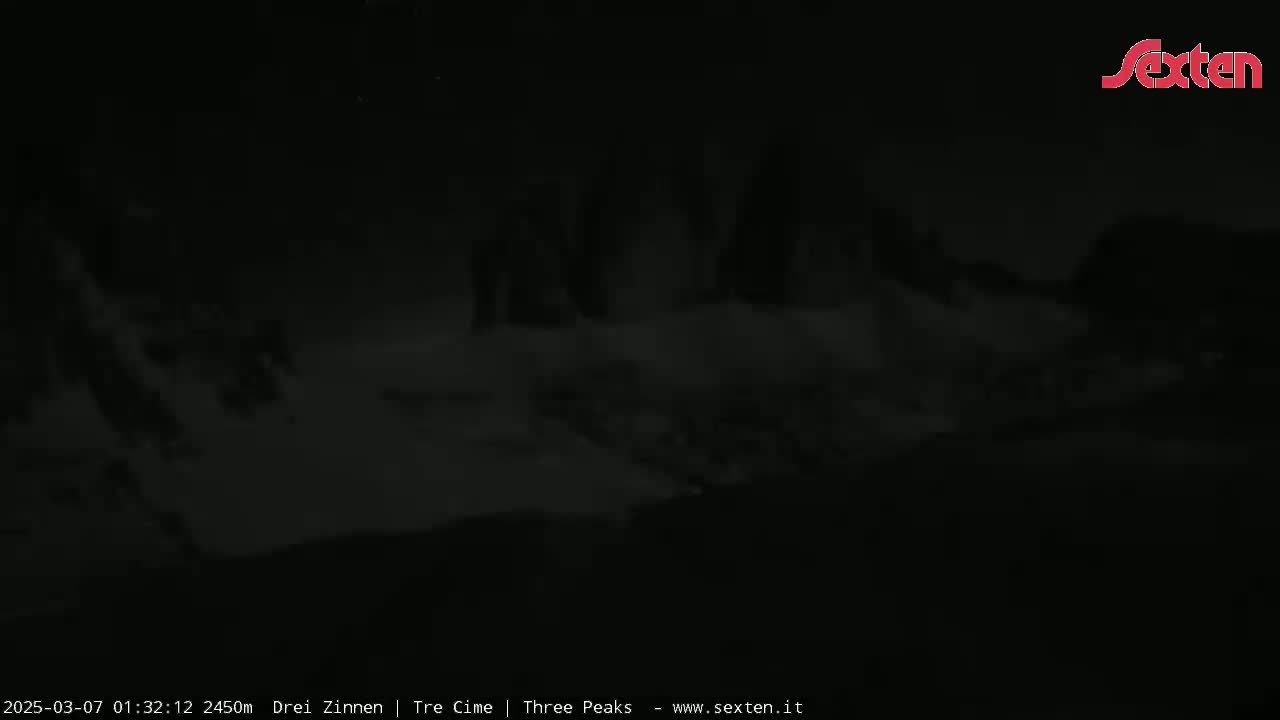 A dark, nighttime landscape is mostly obscured by heavy fog or clouds.