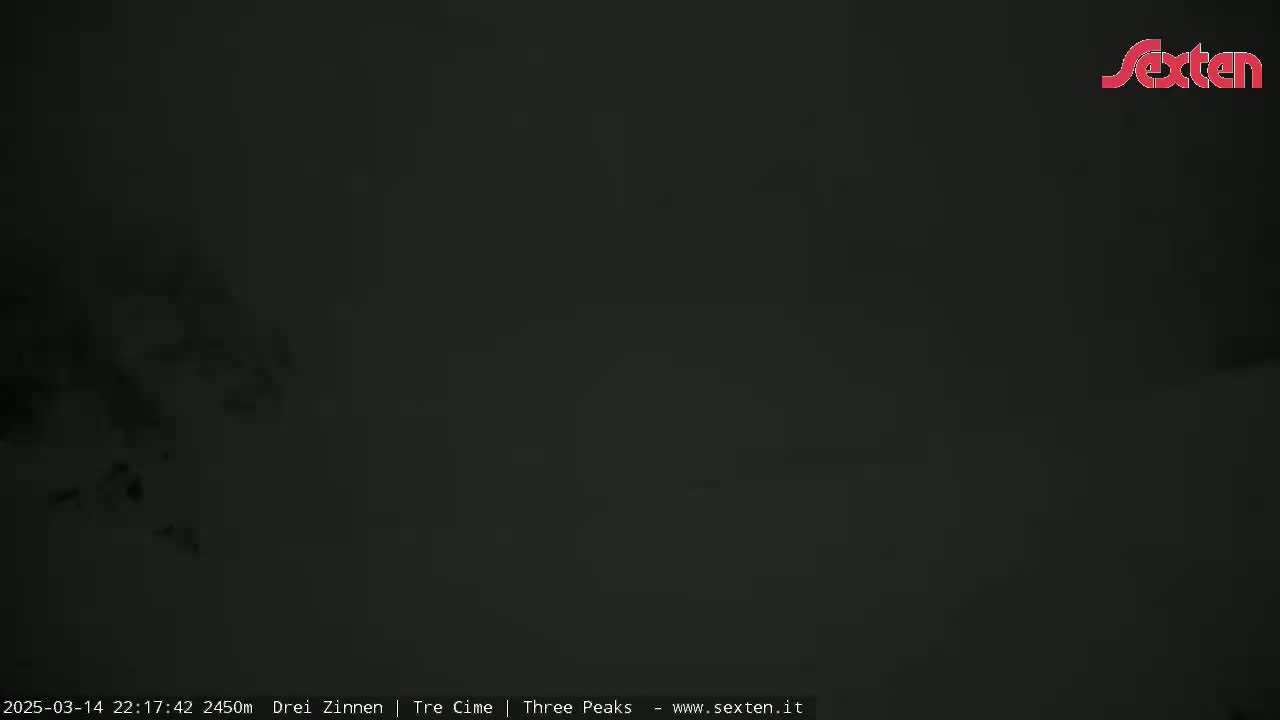 A dark, blurry image shows a nighttime, possibly snowy, outdoor scene with very low visibility.