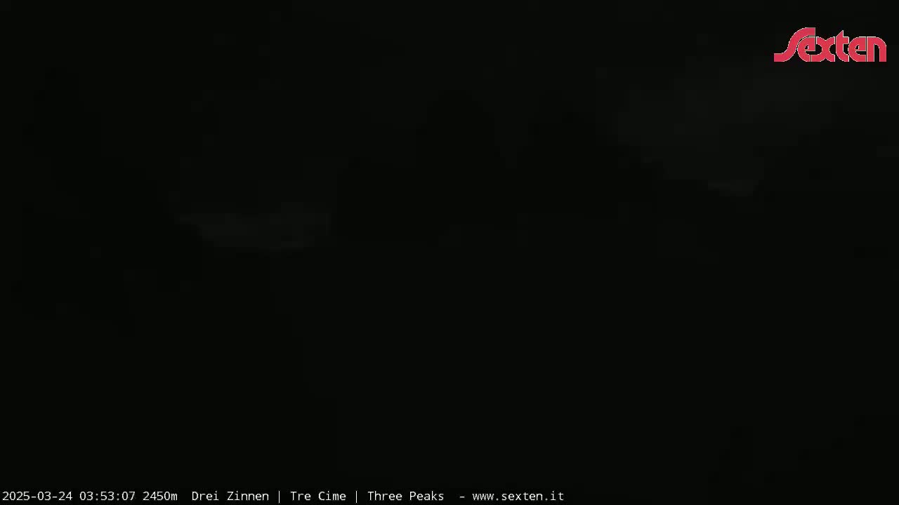 A dark, nighttime scene with faint, light gray clouds or fog.