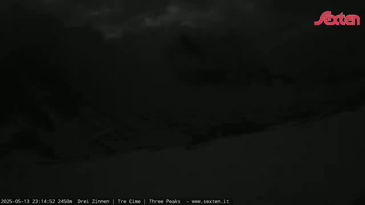 A dark, cloudy night scene shows a mostly obscured landscape.