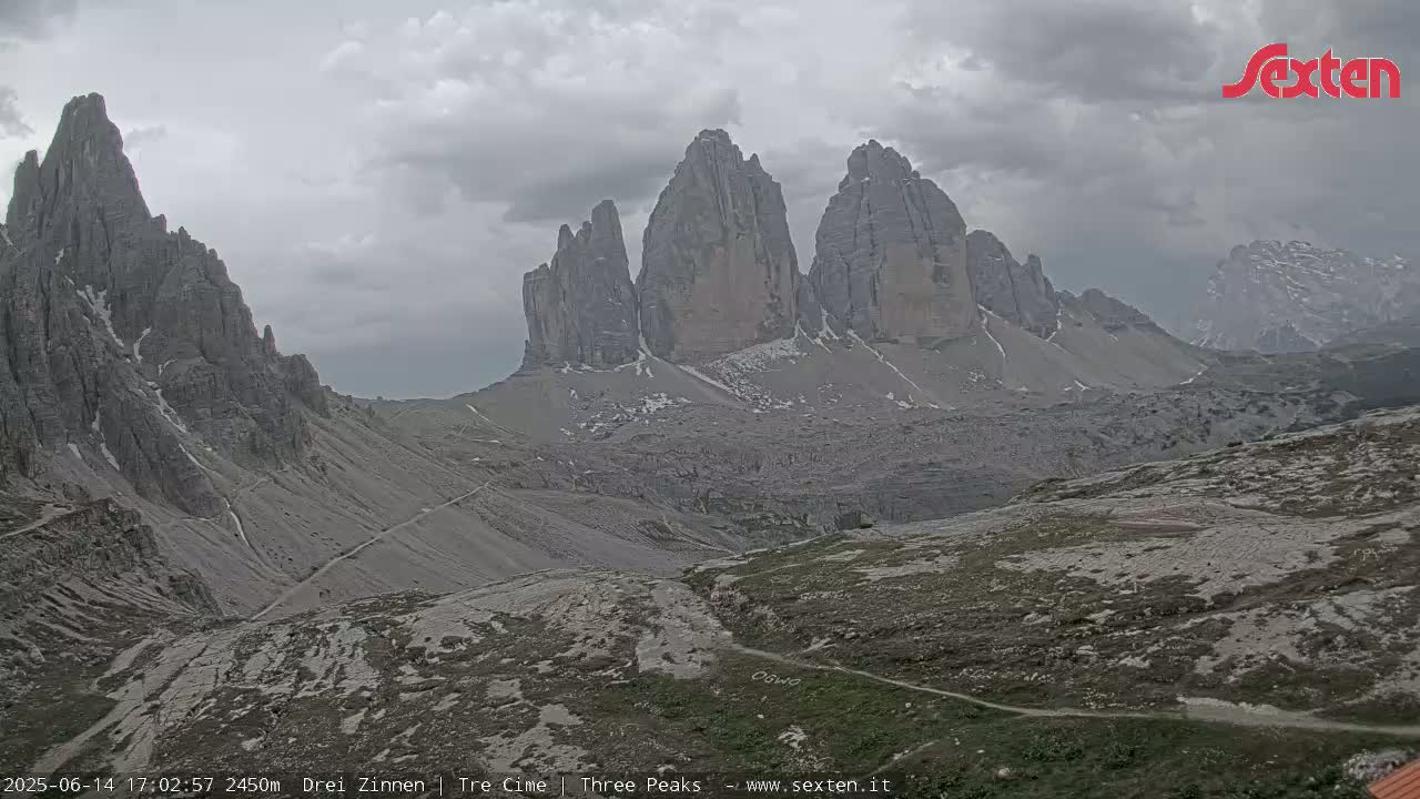 A mountain range with several prominent peaks is visible under an overcast sky.