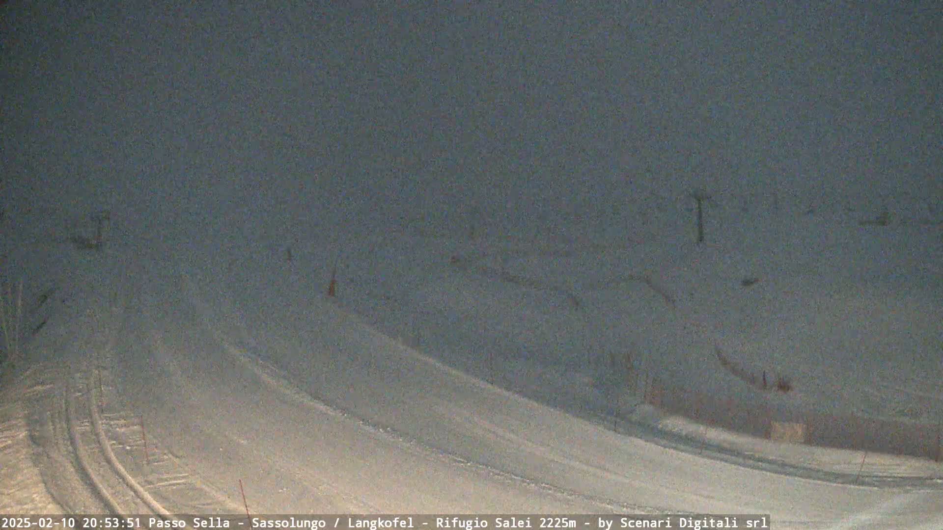 A snow-covered slope is visible under a dark, overcast sky.