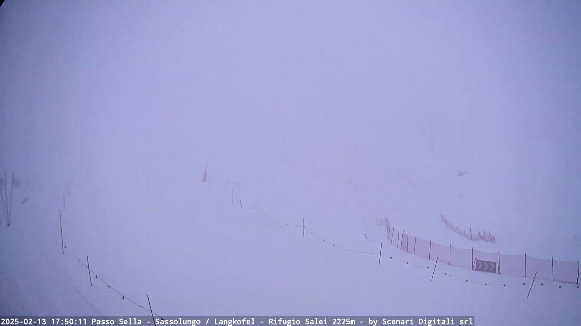 A snowy, foggy landscape with snow fences is visible.