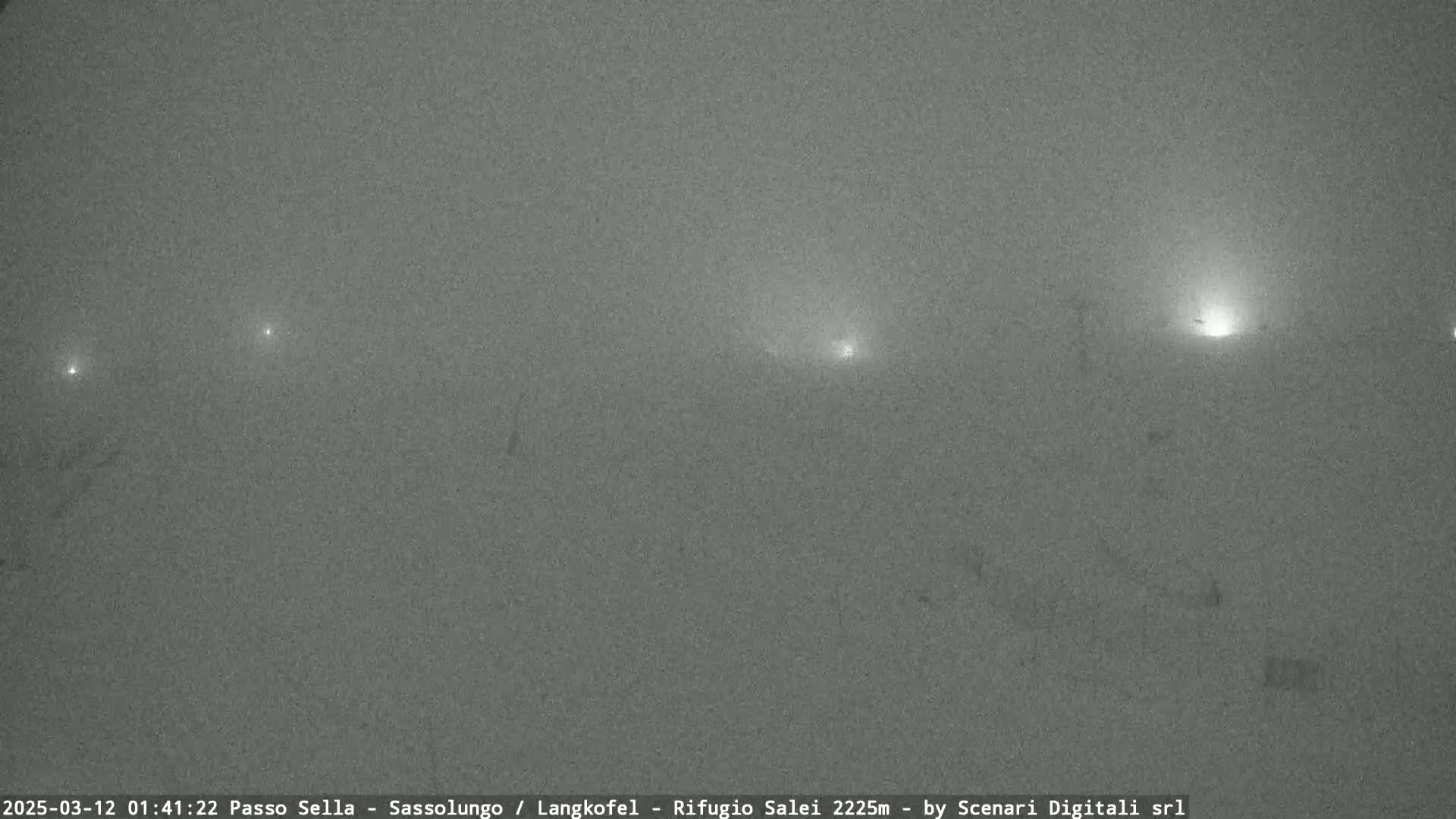 A foggy, nighttime landscape is visible with several distant lights.