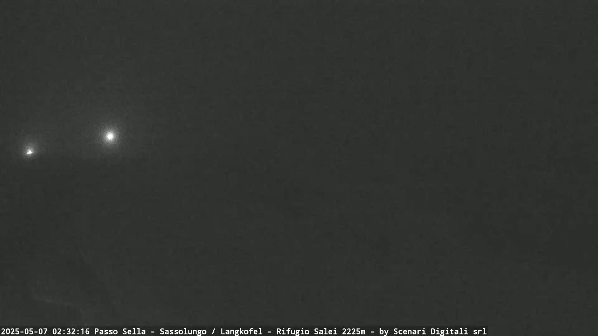 Three distant lights are visible in a dark, nighttime sky.