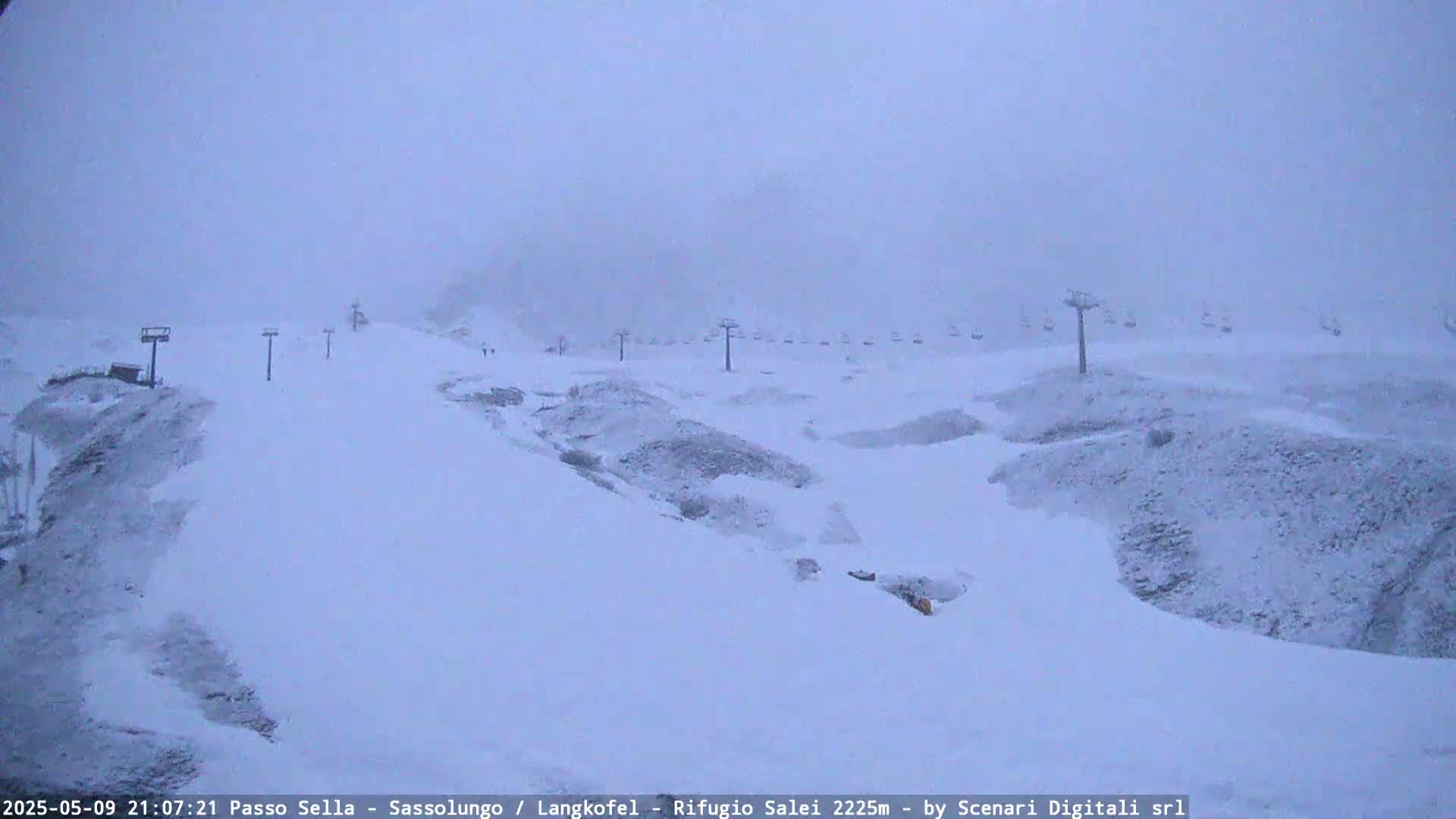 A snow-covered ski slope with several chairlifts is visible under heavy snowfall.
