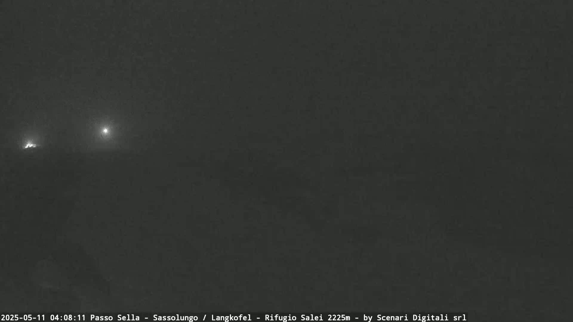 Two distant lights are visible in the dark, foggy night.