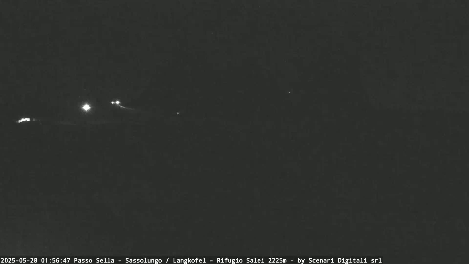 A nighttime long shot shows a dark landscape with a few distant headlights visible.