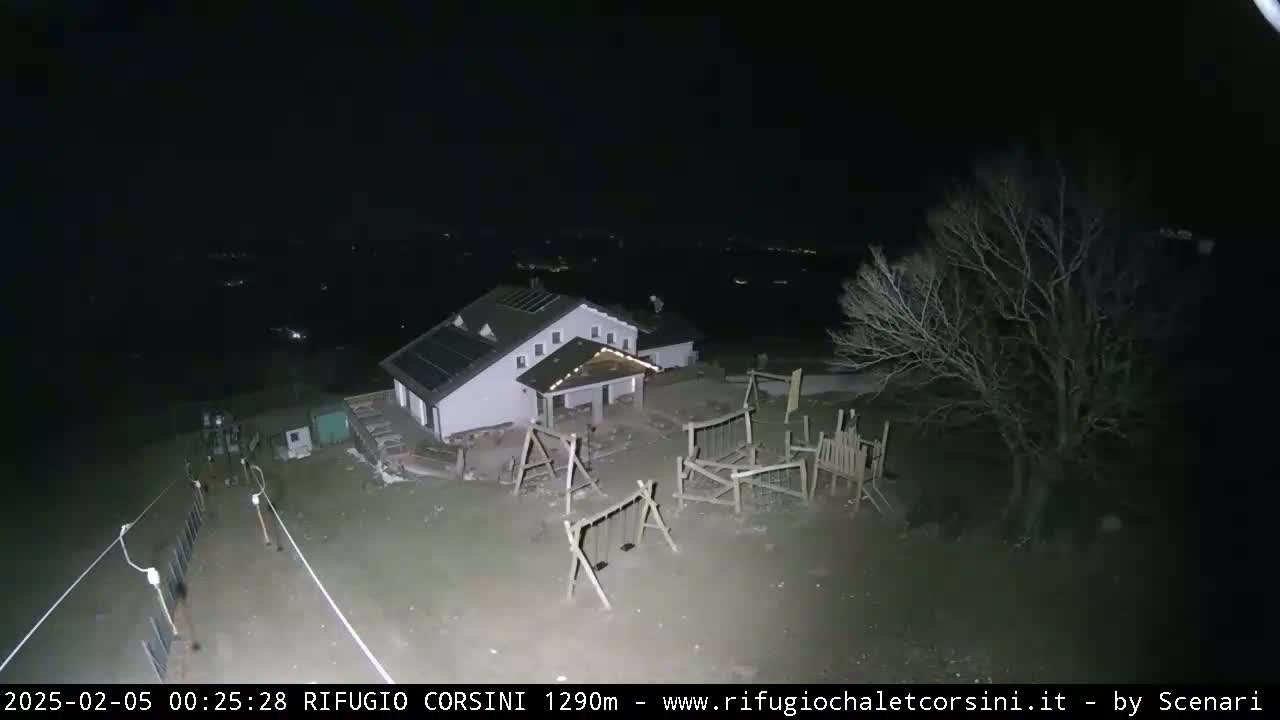 A building with a playground is visible at night under a clear, dark sky.