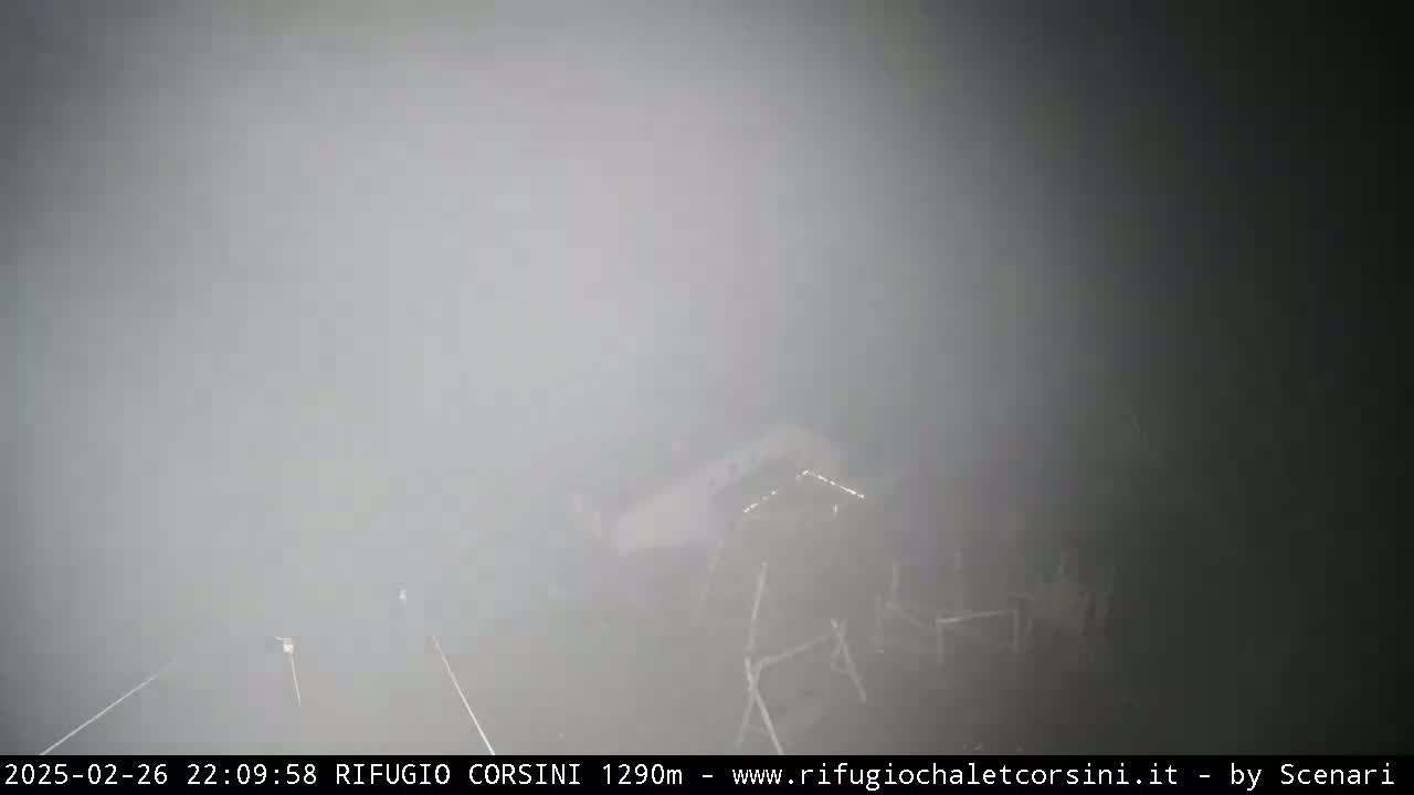 A foggy, outdoor scene shows a dimly lit structure partially obscured by heavy fog.