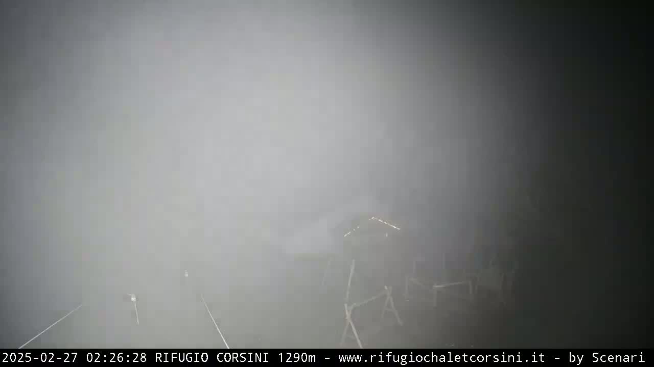 A structure is barely visible through a thick fog.