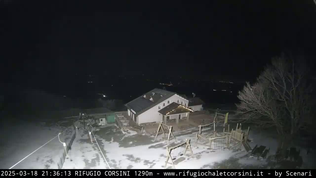 A nighttime, snow-covered playground and building are visible under a dark sky.