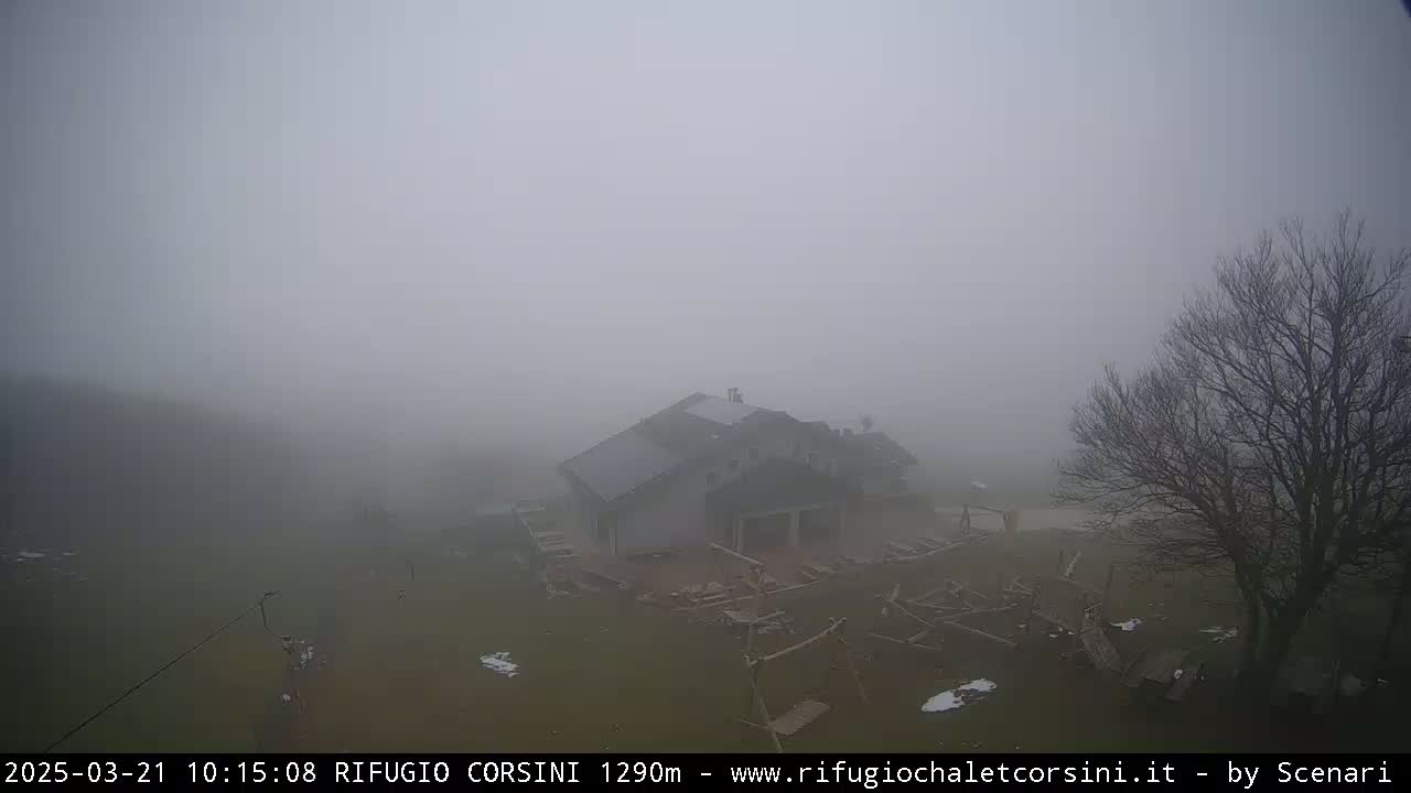 A foggy, outdoor scene shows a building with a playground in front of it, partially obscured by the thick fog.