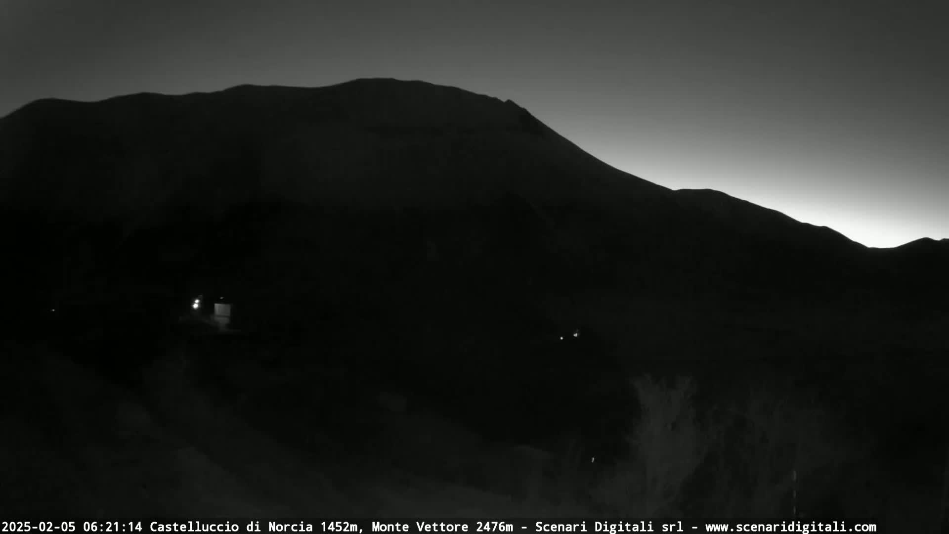A silhouetted mountain range is visible against a twilight sky.