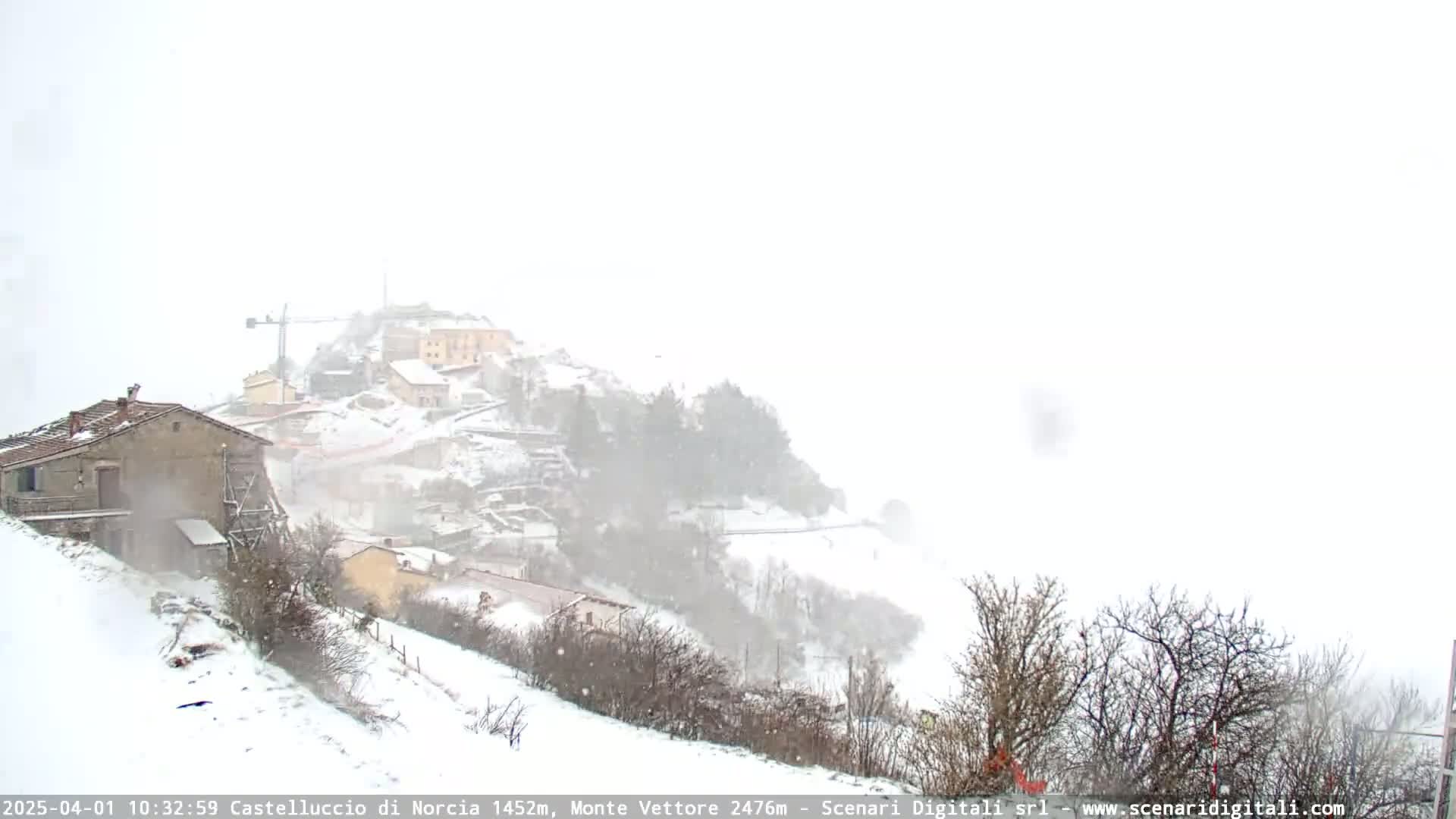 A snow-covered hillside village is viewed during a heavy snowfall.