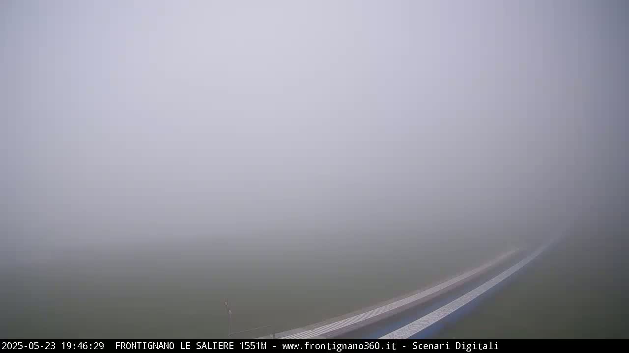 A foggy field is visible, with two parallel lines of what appears to be a structure or walkway in the bottom right corner.