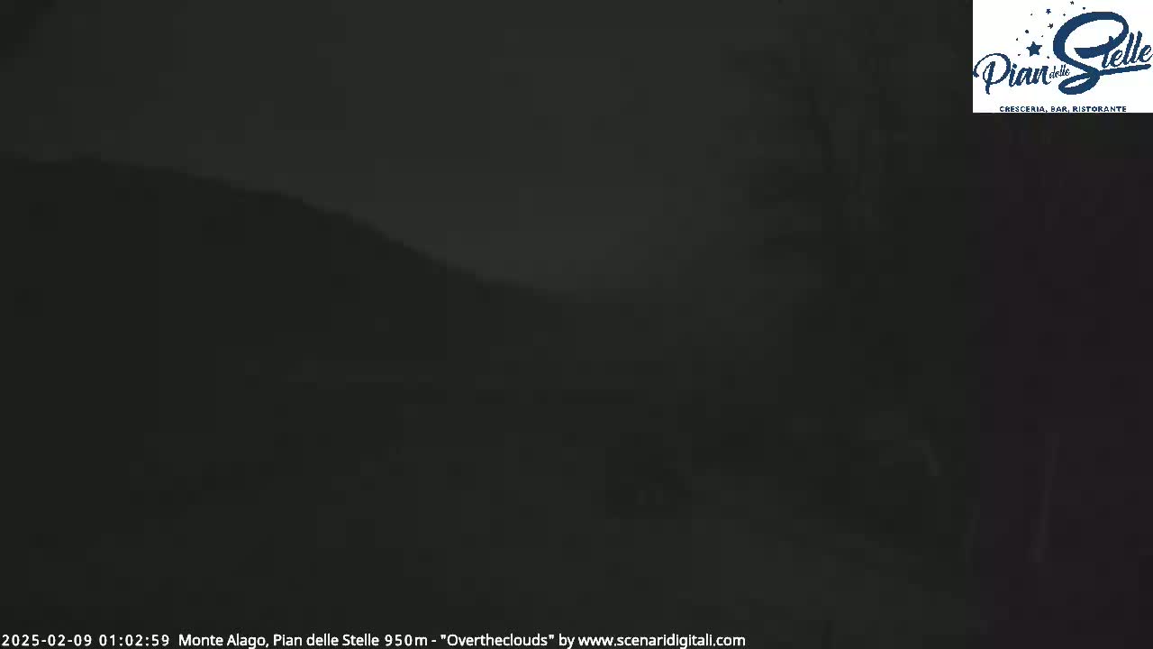 A dark, overcast night scene shows a blurry, dark hillside.