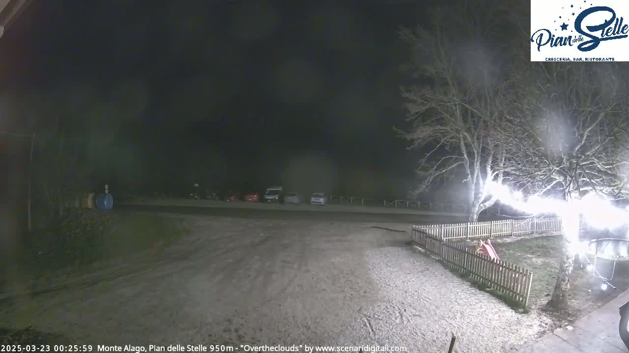 A snow-covered parking lot and playground are visible at night under an overcast sky.