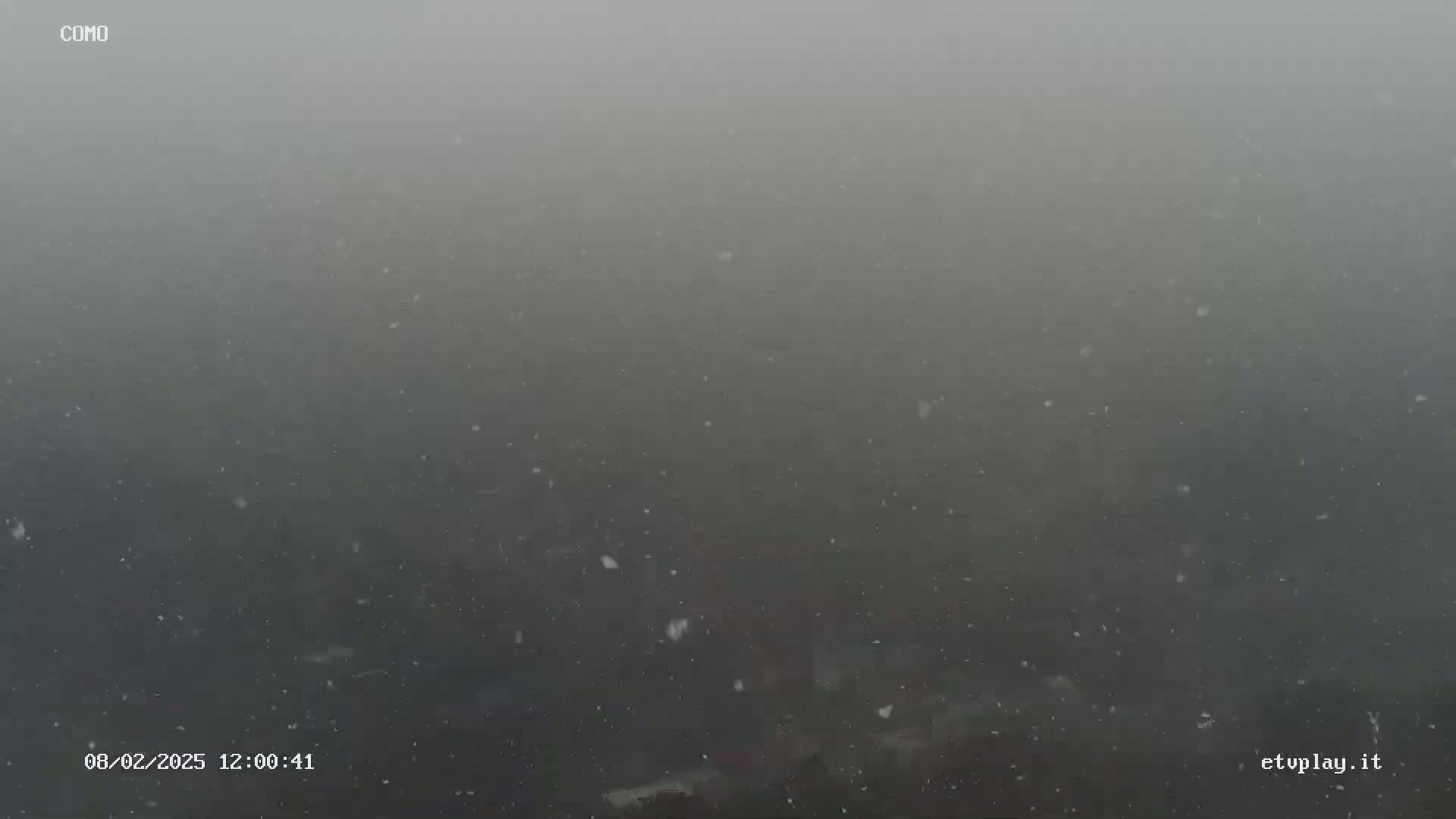 A hazy, snowy scene is visible, with many small snowflakes falling.