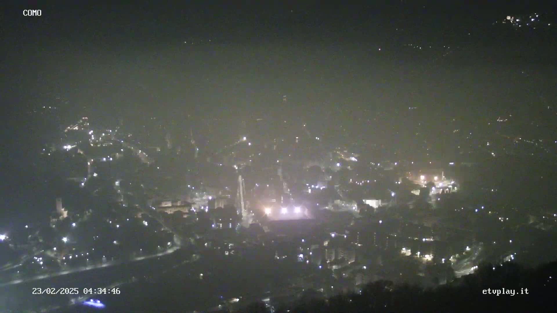 A hazy, nighttime, high-angle view of a town with scattered lights.