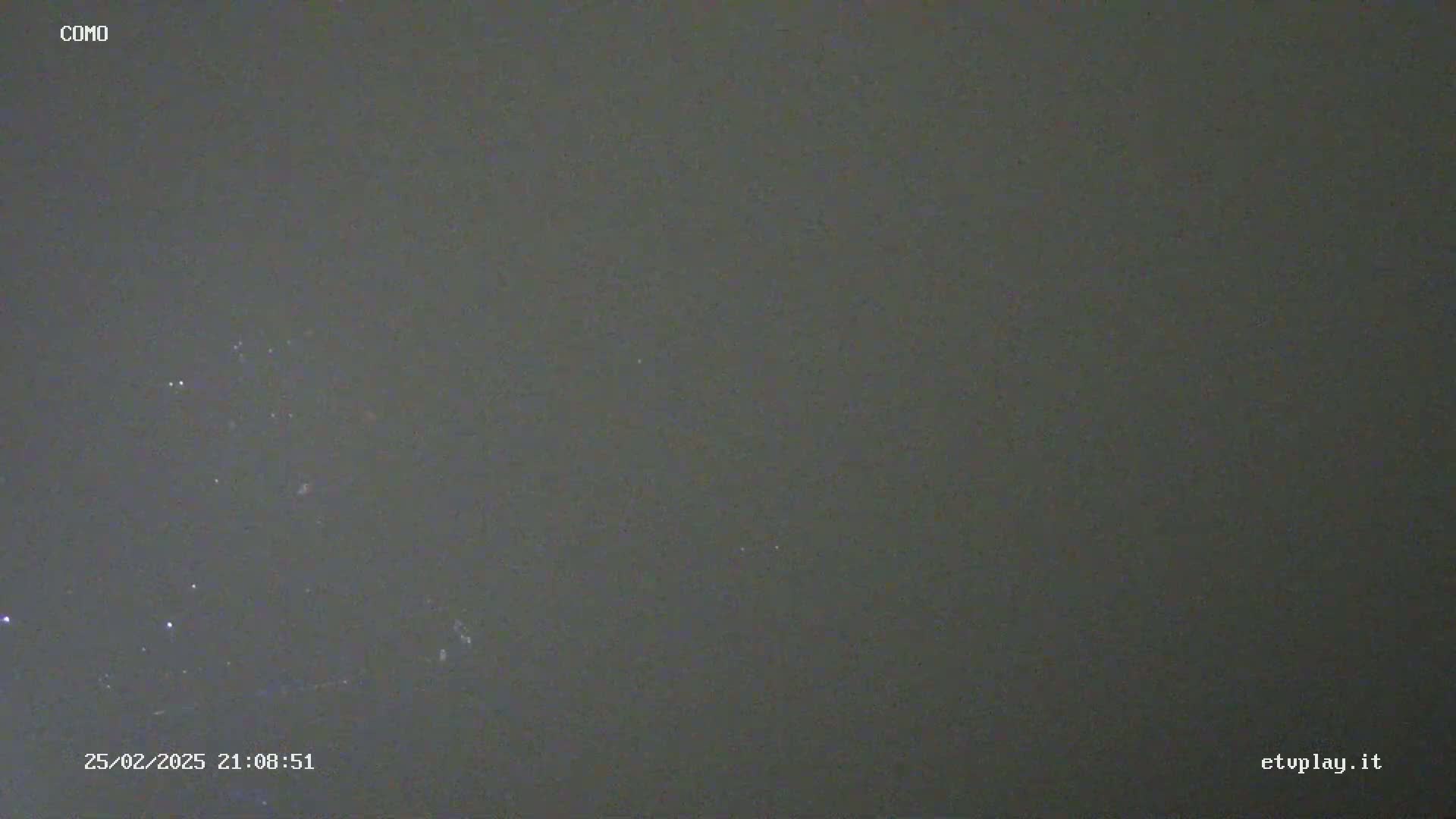 A dark gray, overcast night sky is speckled with a few faint lights.