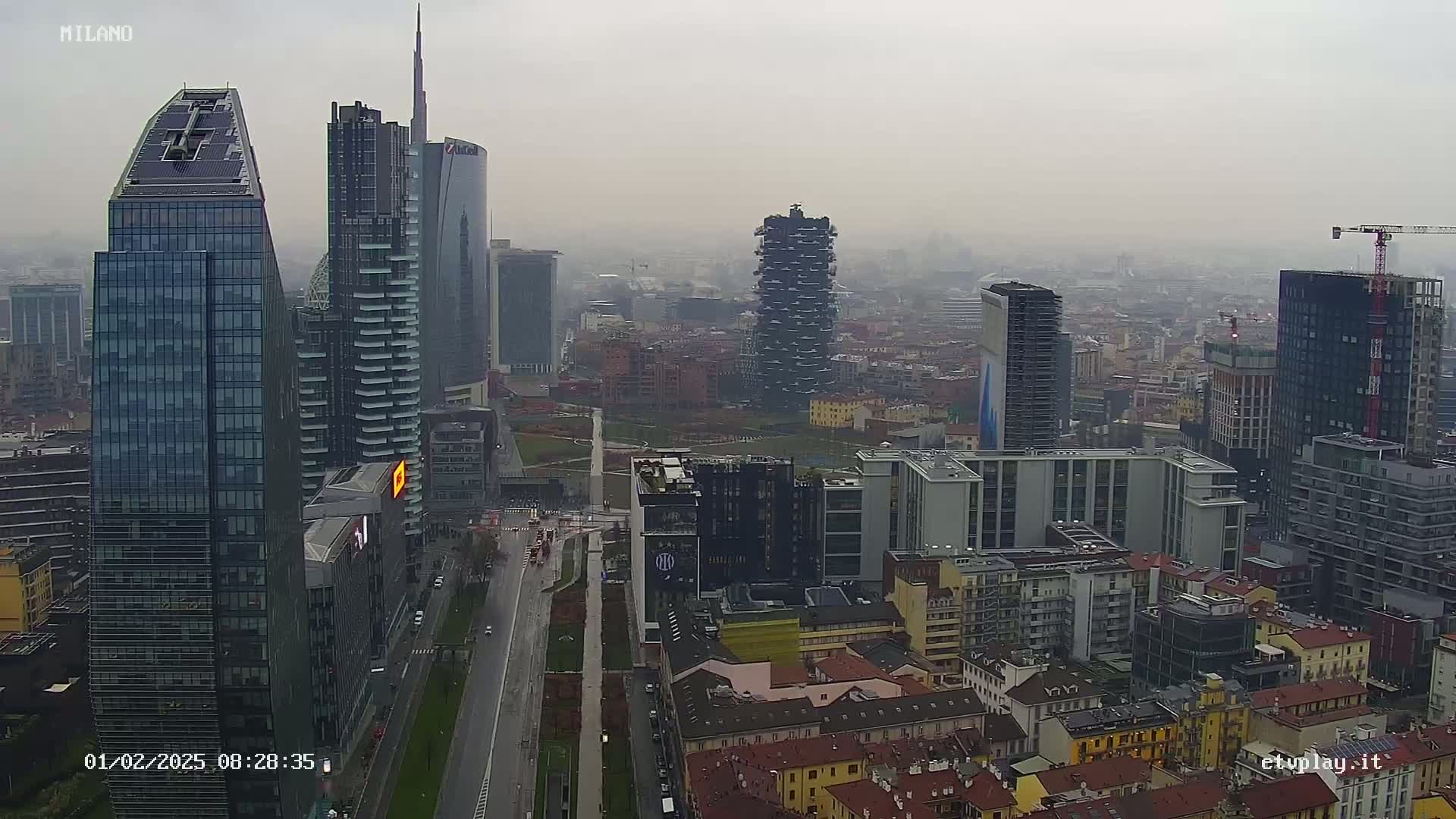 A hazy, overcast view of a dense cityscape with numerous skyscrapers and high-rise buildings, including one under construction.