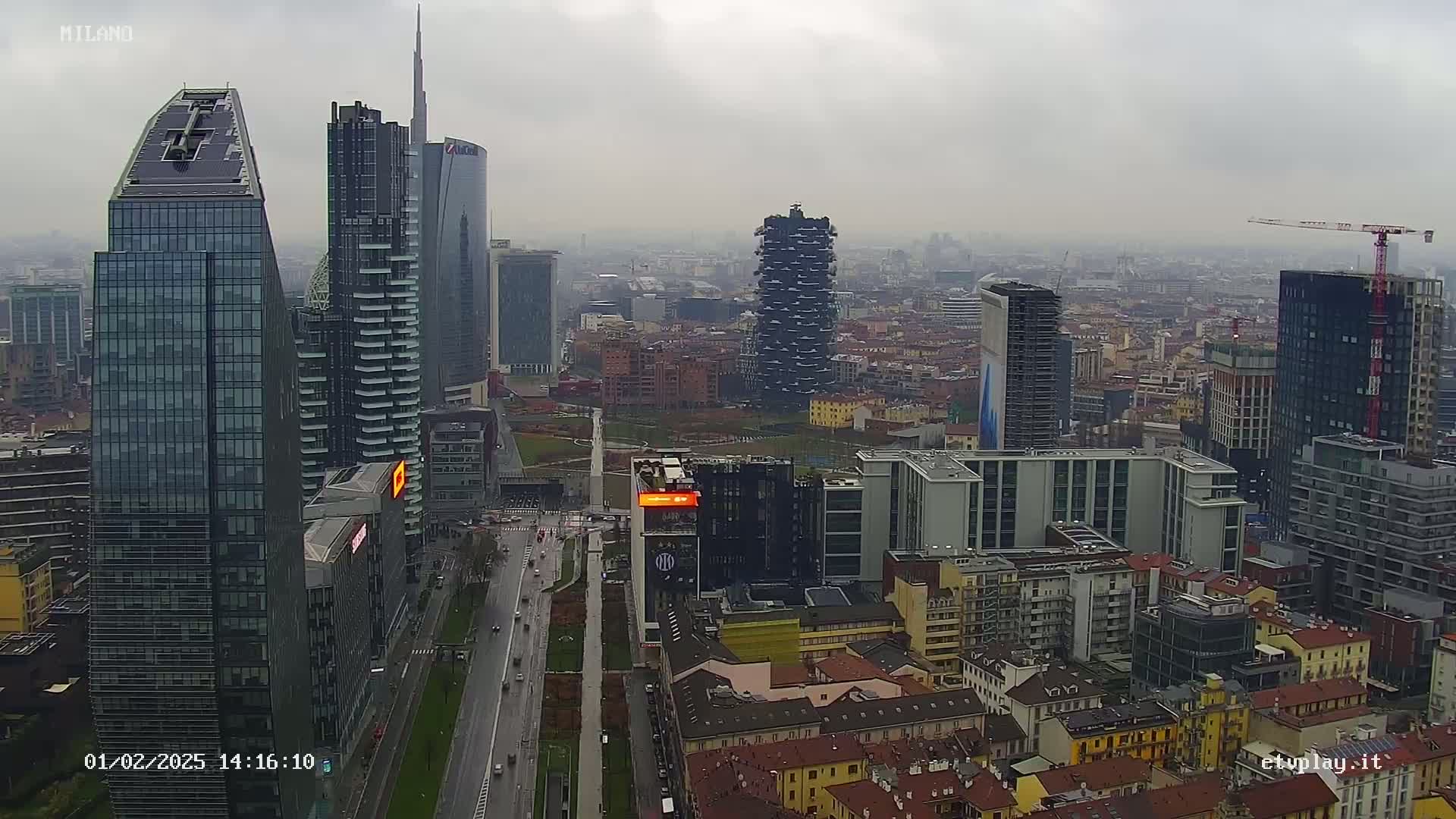 A cityscape of numerous modern and older buildings on an overcast day, with a highway visible below.