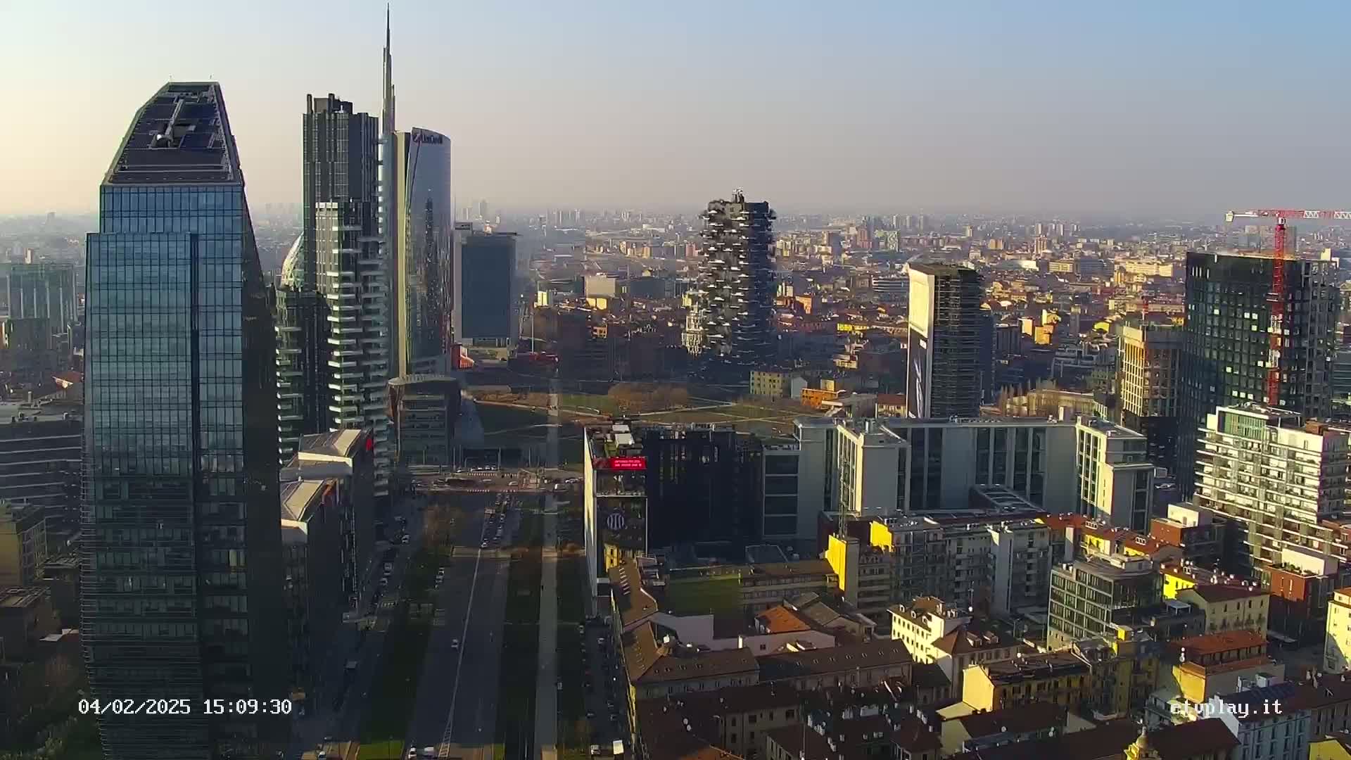 An aerial view of a city skyline on a hazy day, showing numerous skyscrapers and surrounding buildings.