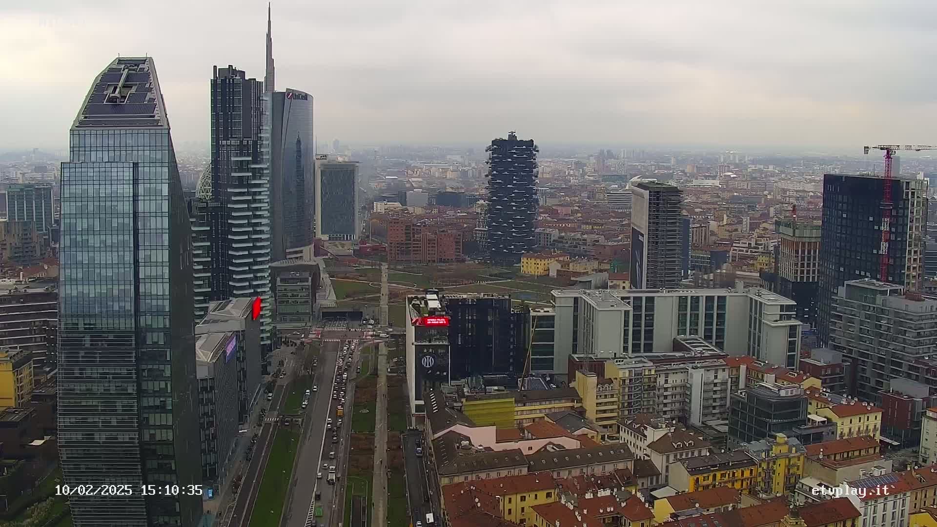 A high-angle, long shot of a city skyline on an overcast day, featuring numerous skyscrapers and surrounding lower buildings.