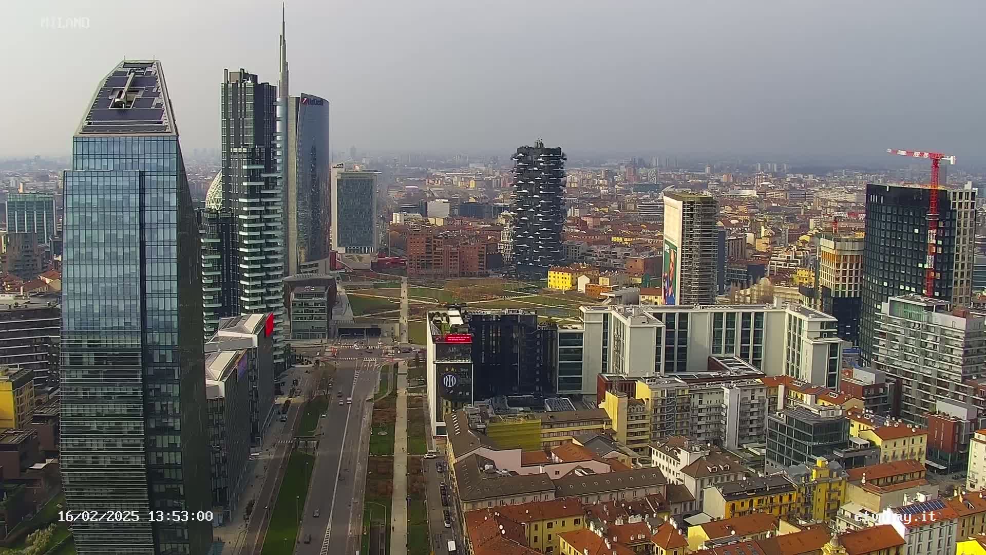 An aerial view of a city skyline on an overcast day, showing numerous skyscrapers and surrounding buildings.