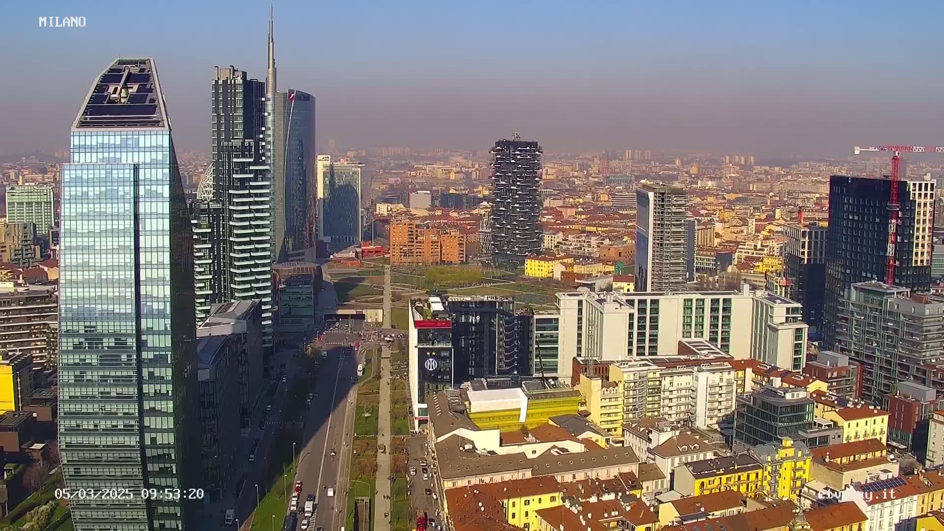 An aerial view of a city skyline on a hazy day, showing numerous skyscrapers and surrounding buildings.