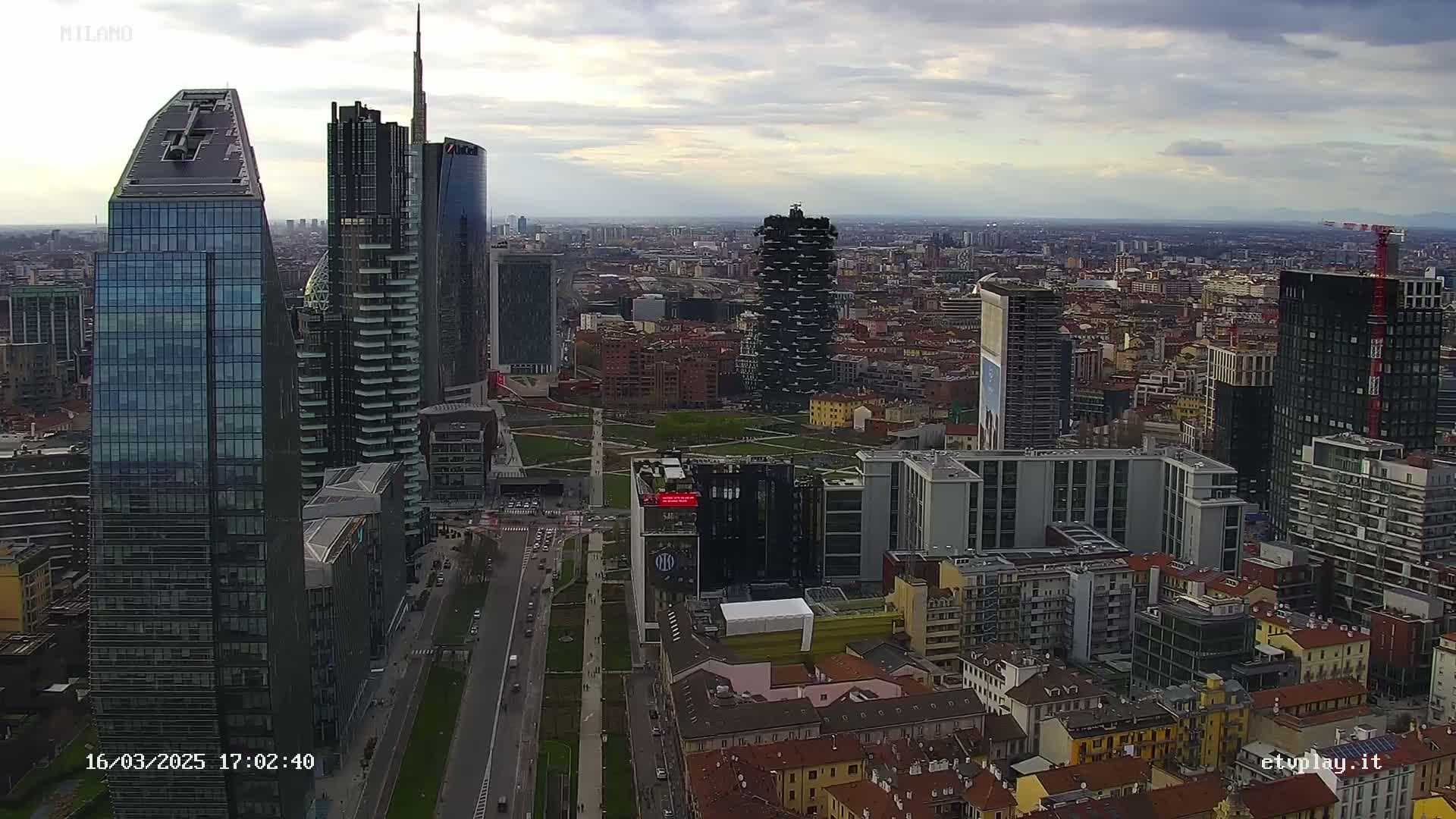 An aerial view of a city skyline on an overcast day, showing numerous skyscrapers and surrounding buildings.