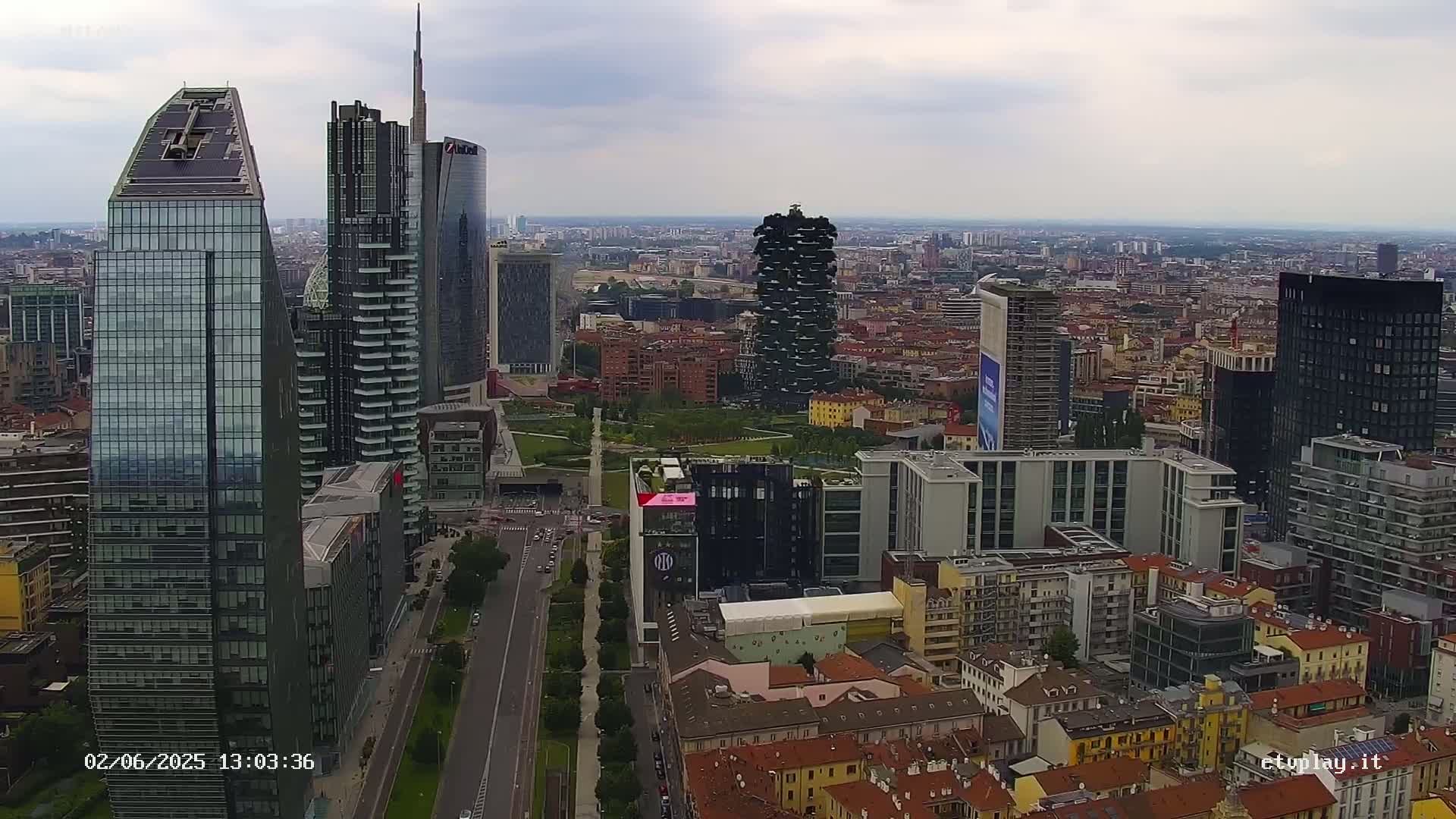 An aerial view of a city skyline on an overcast day, showing numerous skyscrapers and surrounding buildings.