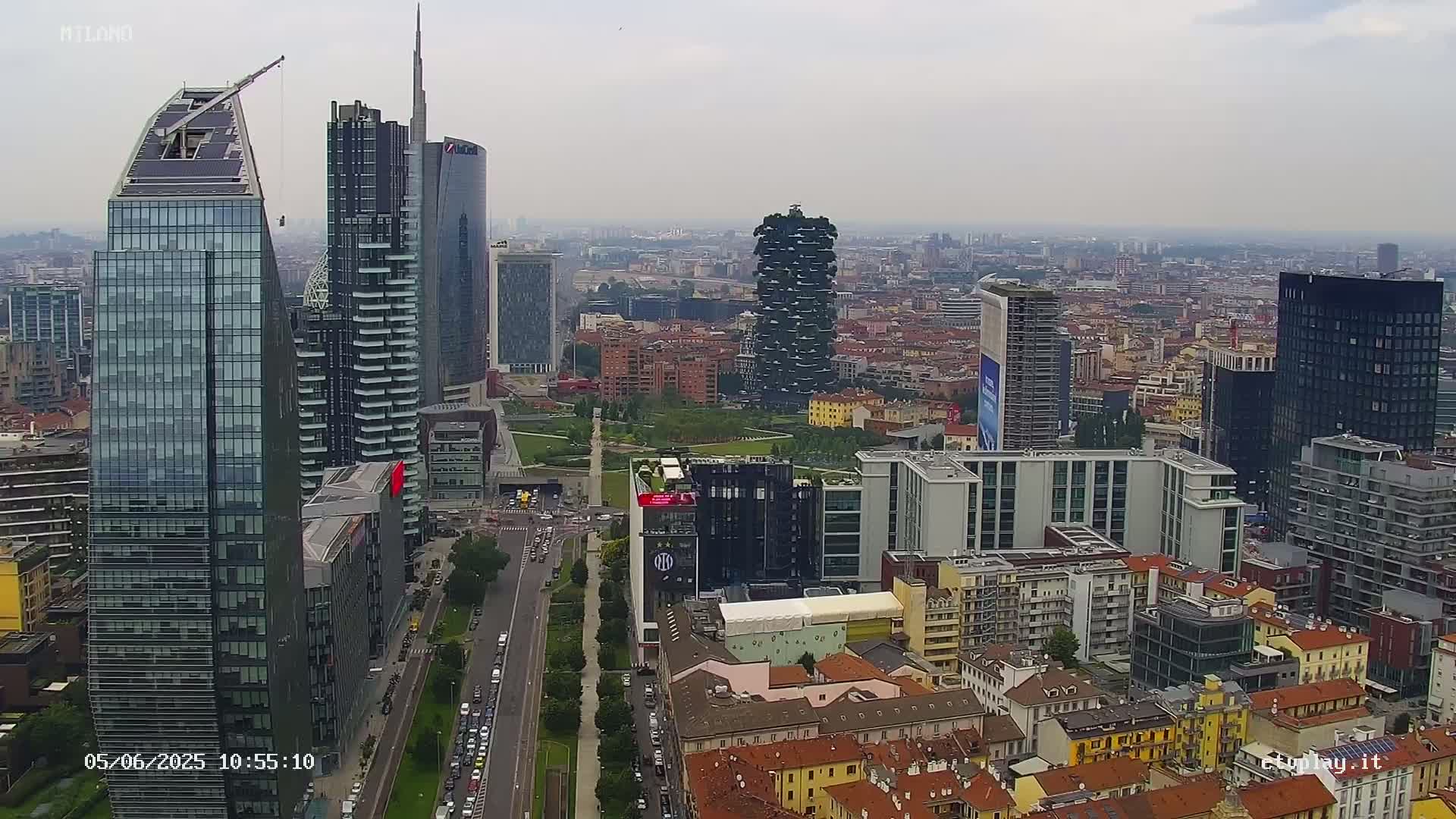 An aerial view of a city skyline on an overcast day, showing numerous skyscrapers and surrounding buildings.