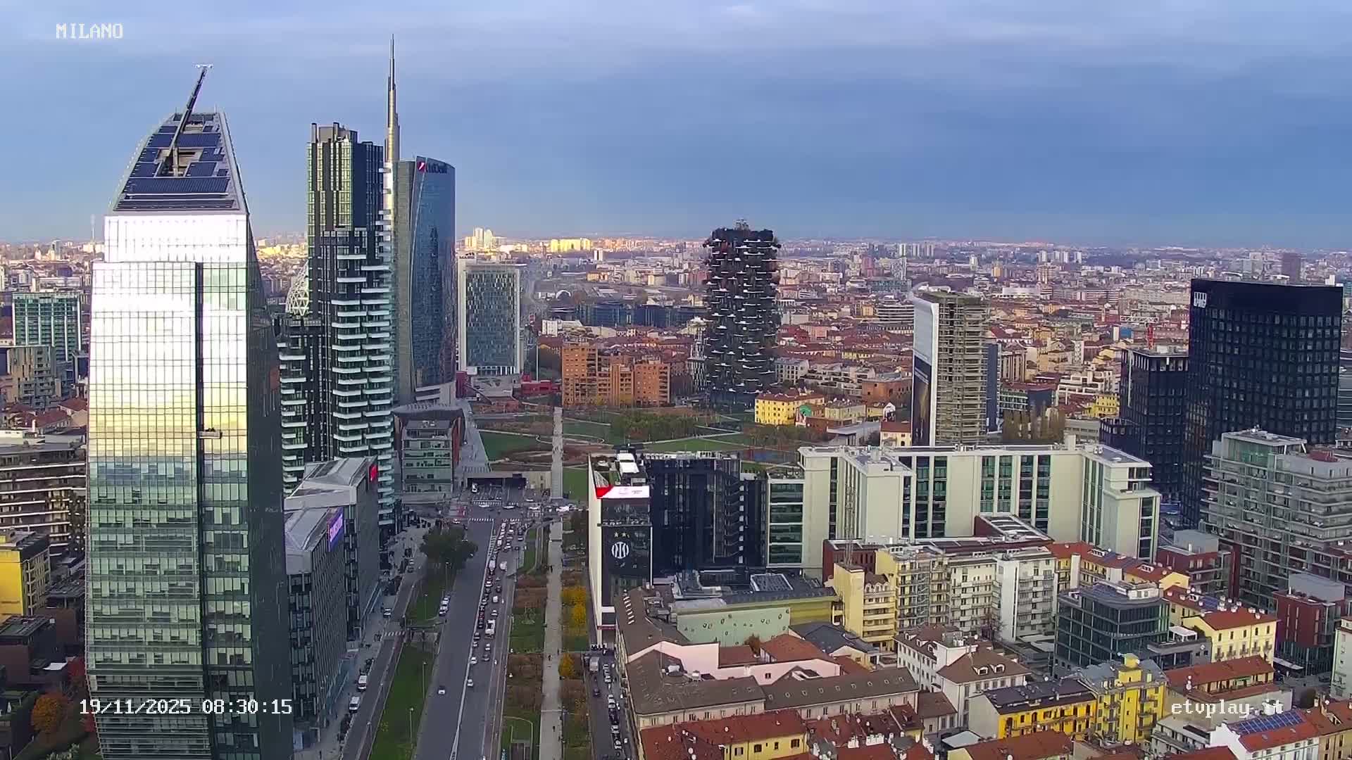 A hazy nighttime cityscape is visible through thick fog or mist, featuring illuminated skyscrapers and a bustling street with vehicle lights.