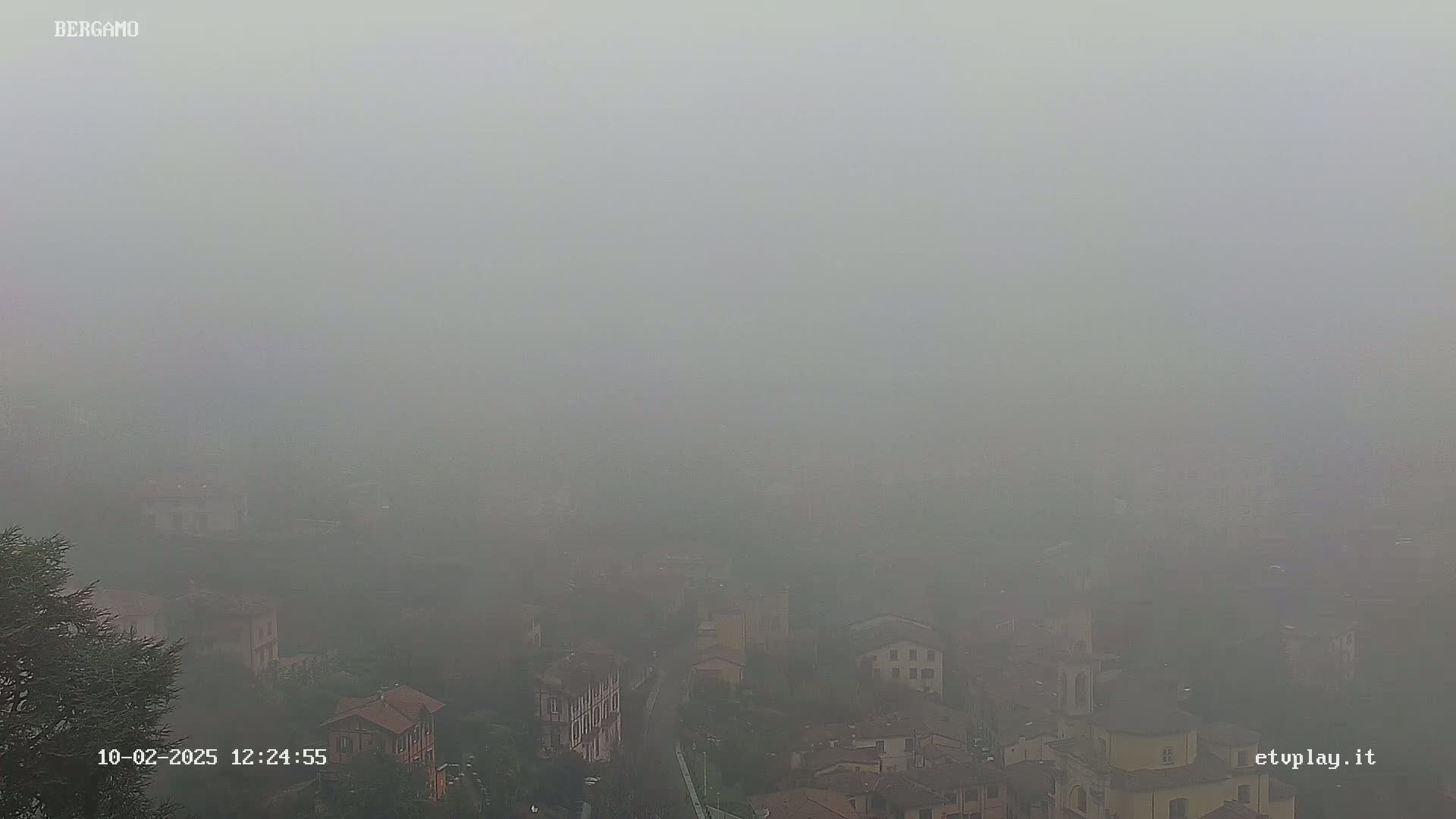 A foggy view of a town reveals a collection of buildings nestled amongst the mist.