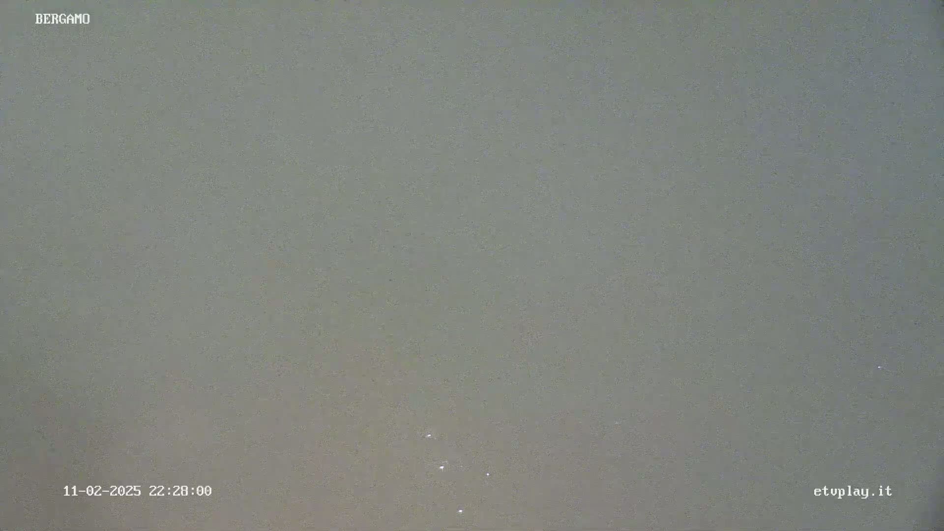 A nighttime, overcast sky shows a few faint lights.