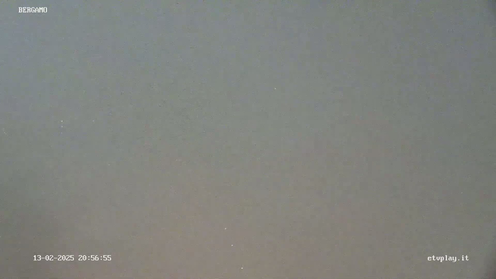 A blurry, gray image shows an overcast sky at night.