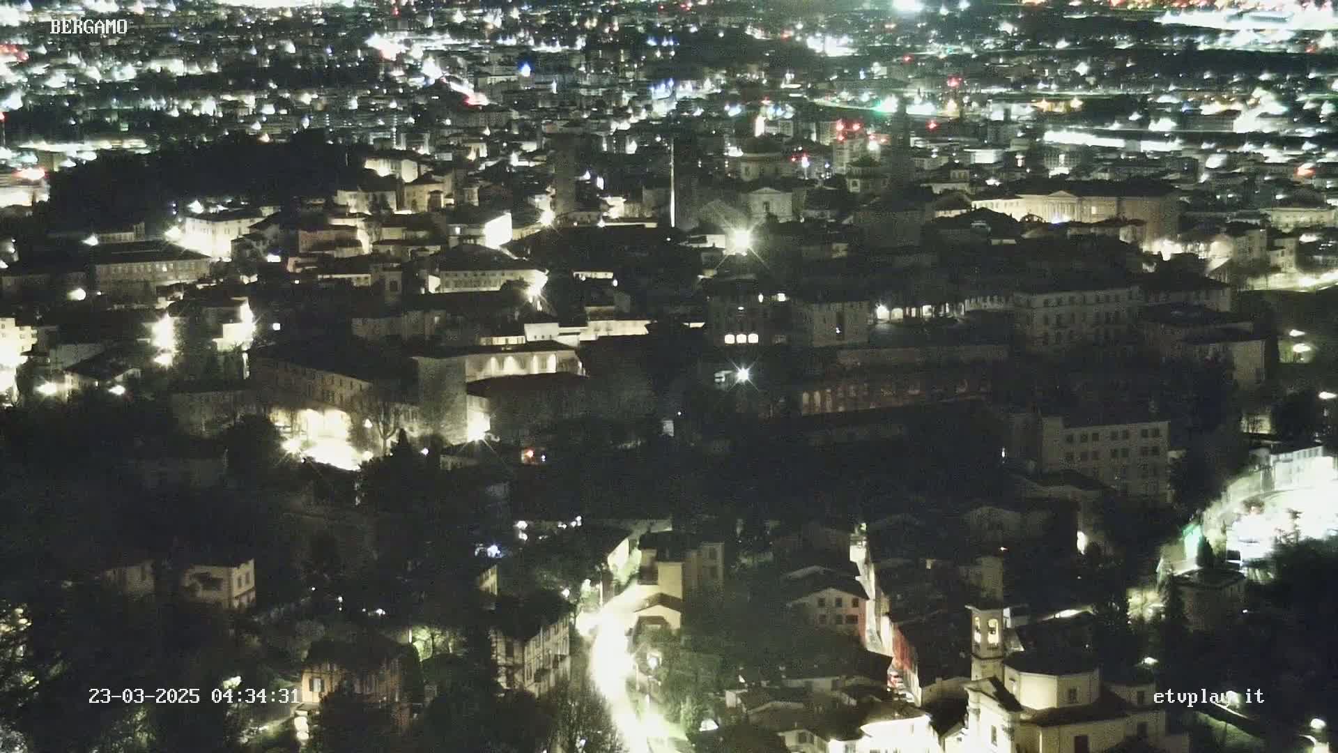 A nighttime aerial view of a city illuminated by streetlights and building lights.