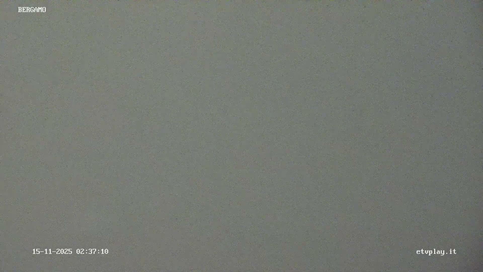 The image displays a uniform, grainy gray field, indicating extremely dense fog or heavy cloud cover completely obscuring the view during nighttime.