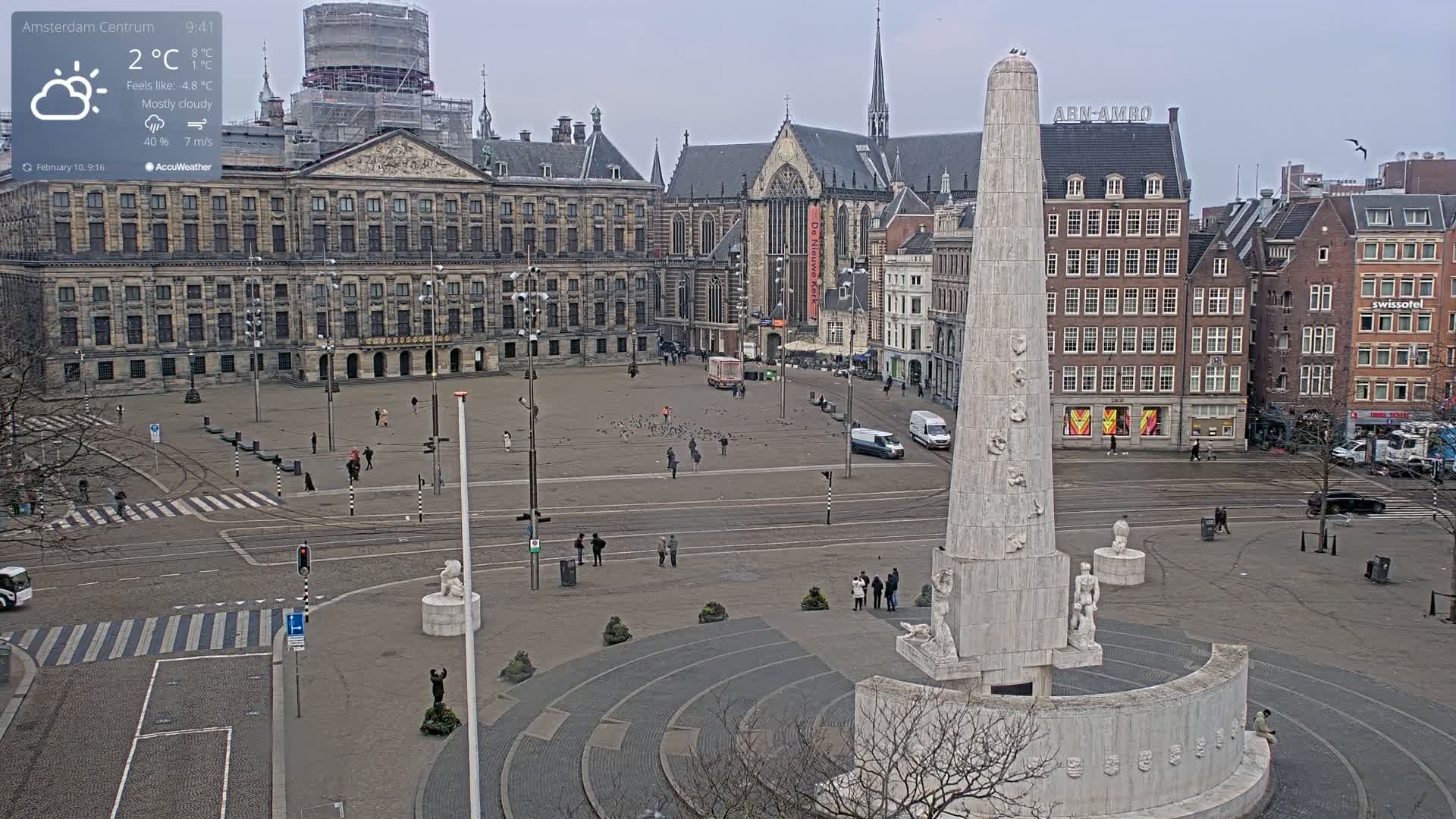 A mostly cloudy, cool day overlooks a large city square with a tall obelisk monument at its center, surrounded by historical buildings.