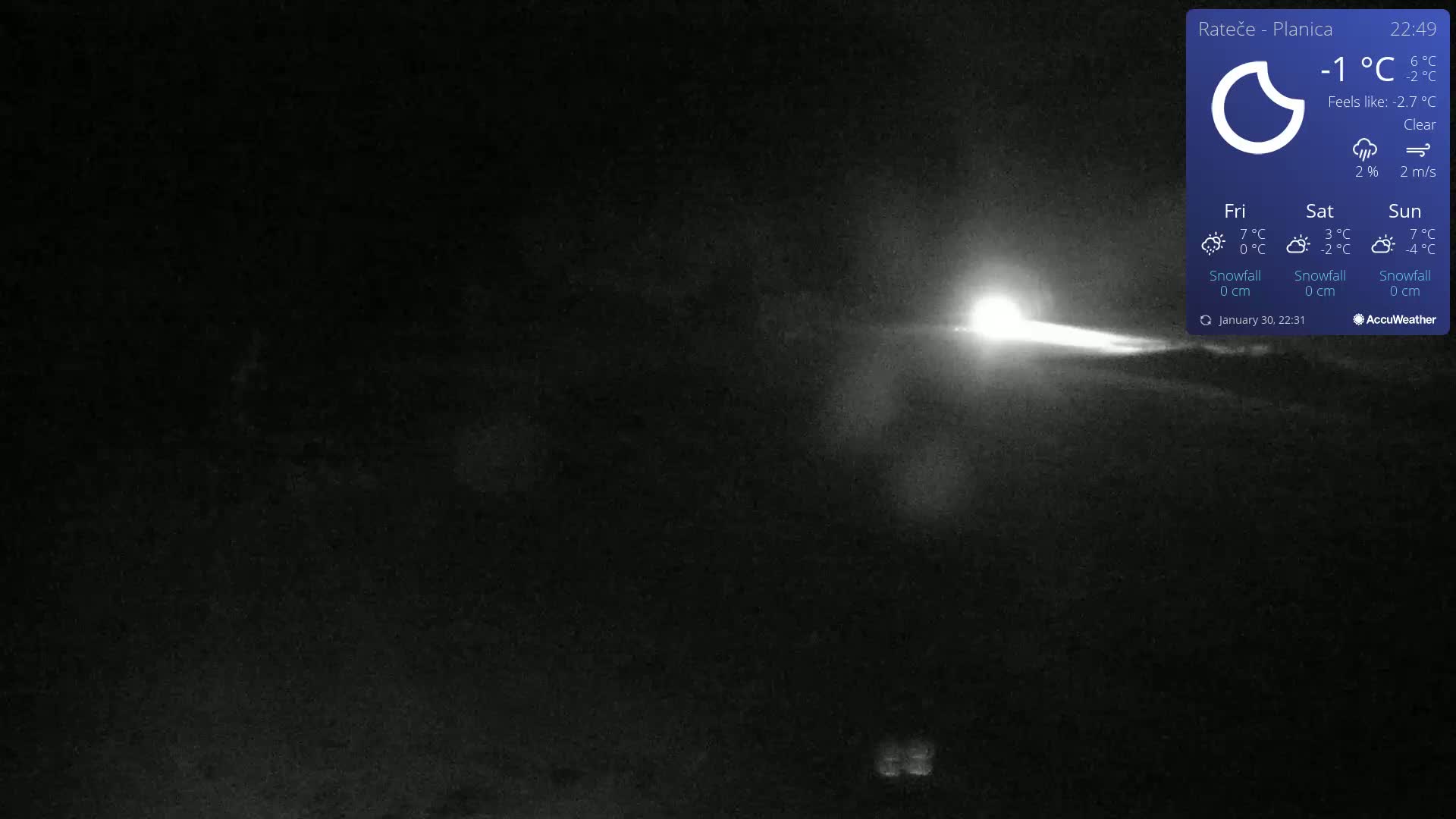 A nighttime, clear, outdoor scene shows a bright light streaking across a dark landscape.