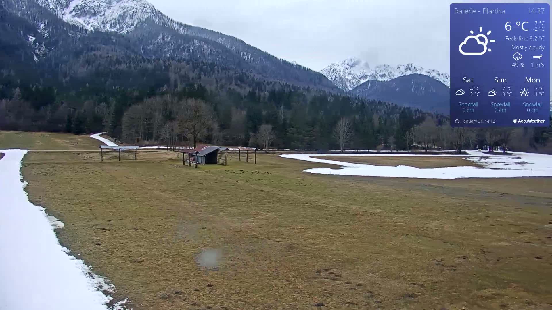 A mostly cloudy day with a temperature of 6°C shows a view of a snow-dusted field and distant, snow-capped mountains.