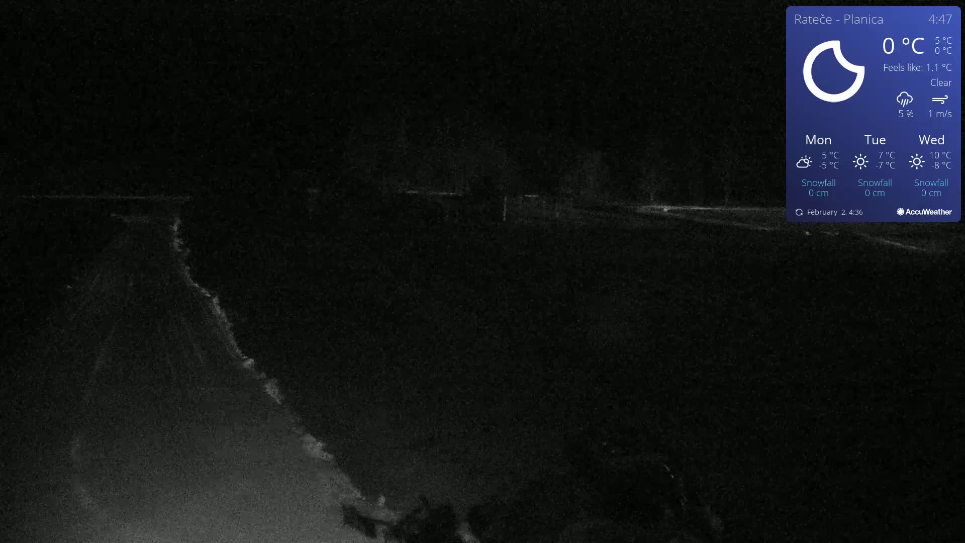 A dark, nighttime scene shows a road or path stretching into the distance under a clear sky.